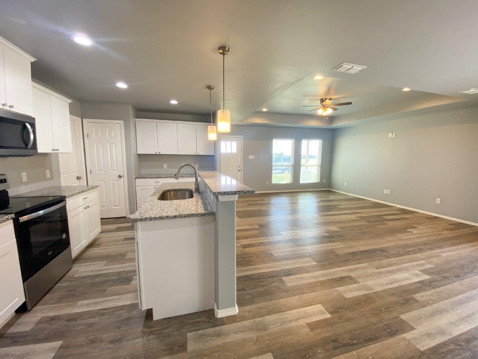 8526 11th Street Lubbock, TX 79416 - Photo 4 of 13 a kitchen with stove cabinets and wooden floor