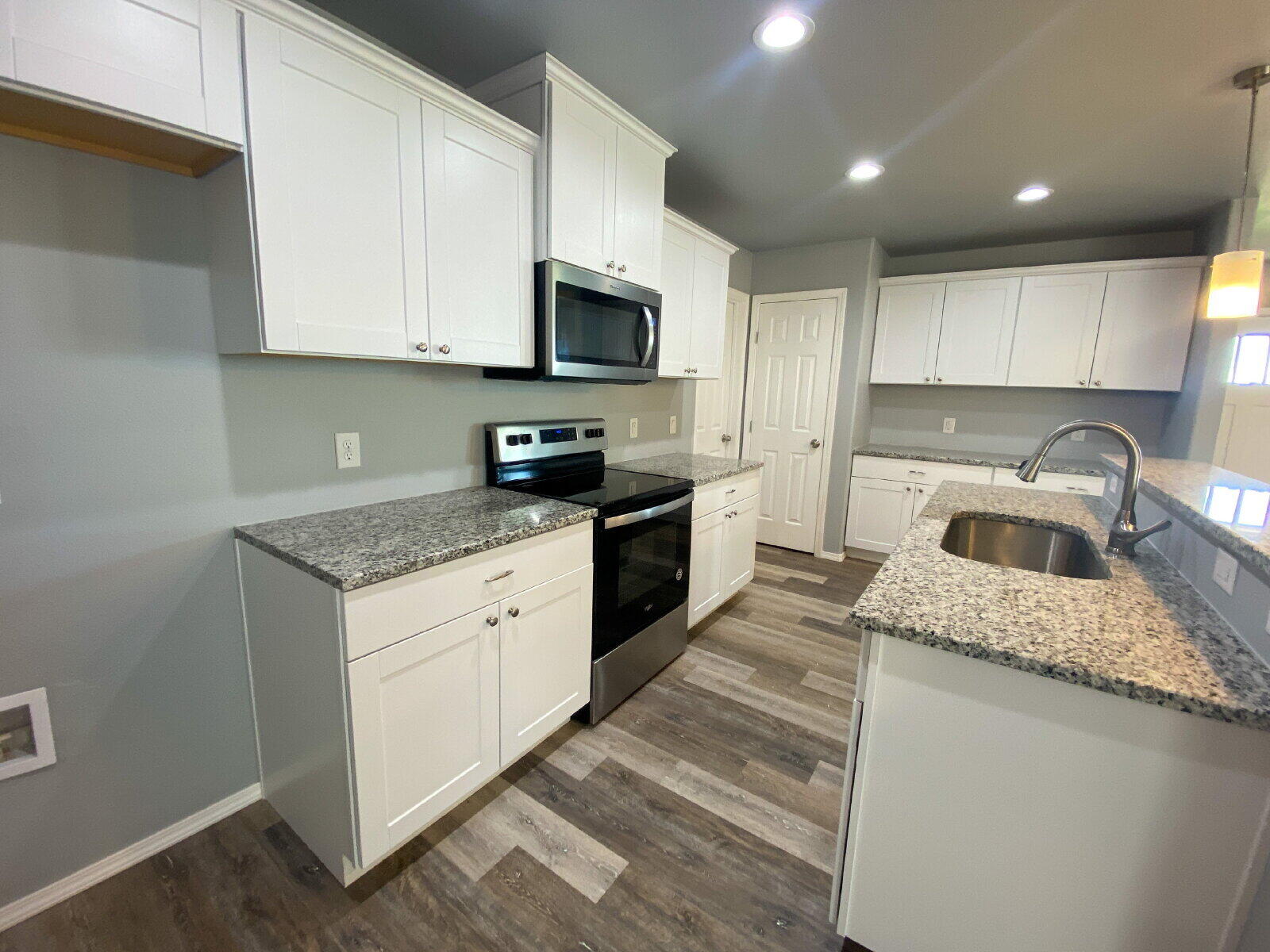 8526 11th Street Lubbock, TX 79416 - Photo 5 of 13 a kitchen with granite countertop a sink a stove top oven and cabinetry