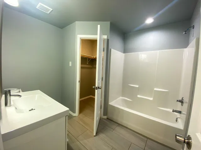 a view of bathroom with a sink and mirror with toilet