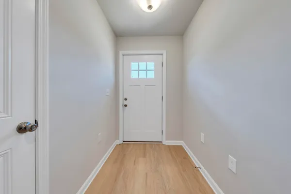 a view of a hallway with wooden floor and a window