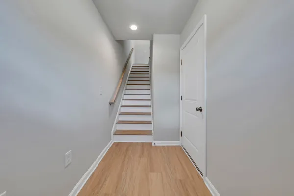 a view of a hallway with wooden floor and entryway