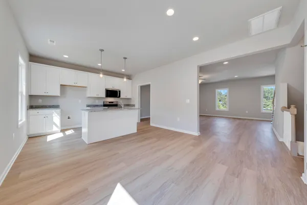 a view of a kitchen with a sink and dishwasher a refrigerator with wooden floor
