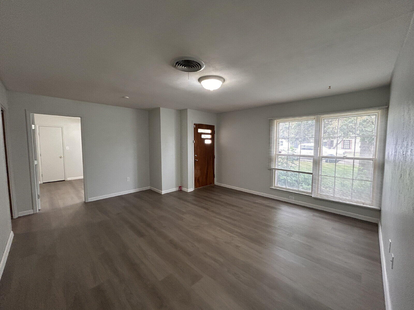 2815 33rd Street Lubbock, TX 79410 - Photo 6 of 9 a view of an empty room with wooden floor and a window