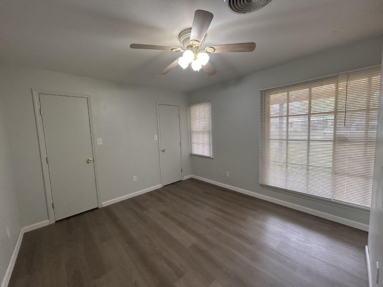 2815 33rd Street Lubbock, TX 79410 - Photo 7 of 9 an empty room with wooden floor chandelier fan and windows