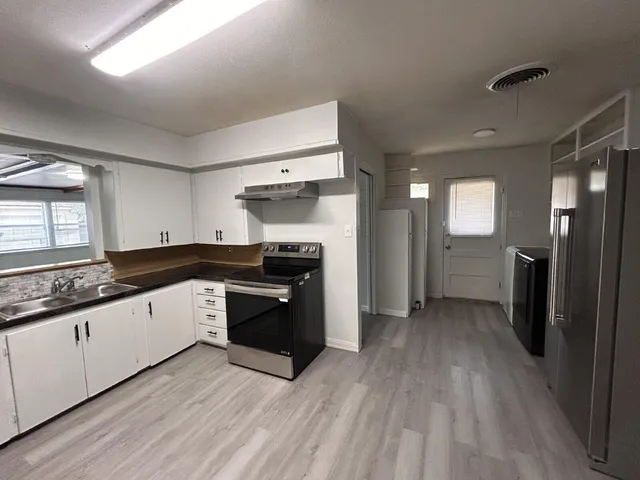 a large kitchen with a sink and stainless steel appliances