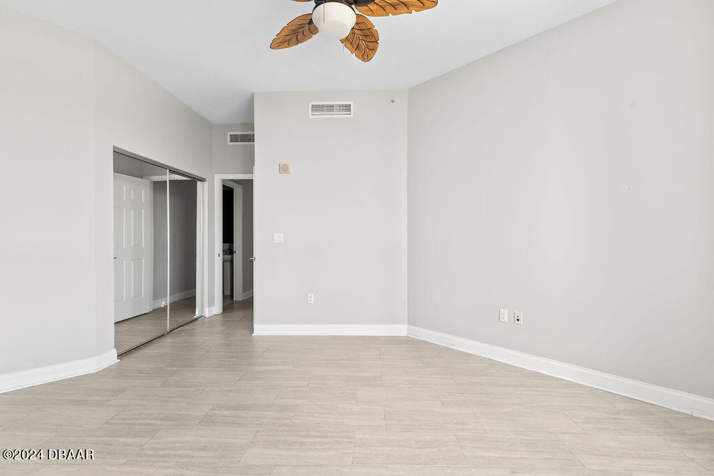 241 Riverside Drive, Unit 2610 Daytona Beach, FL 32117 - Photo 30 of 31 an empty room with a ceiling fan and carpet