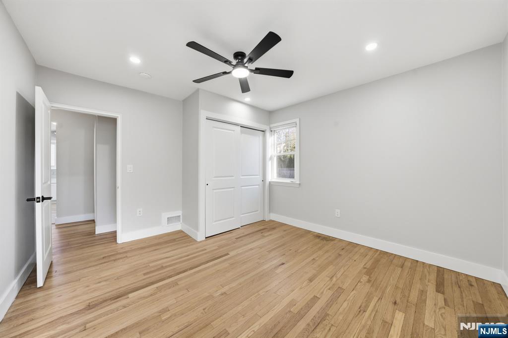 25 Forest Street Closter, NJ 07624 - Photo 11 of 48 an empty room with wooden floor a ceiling fan and windows