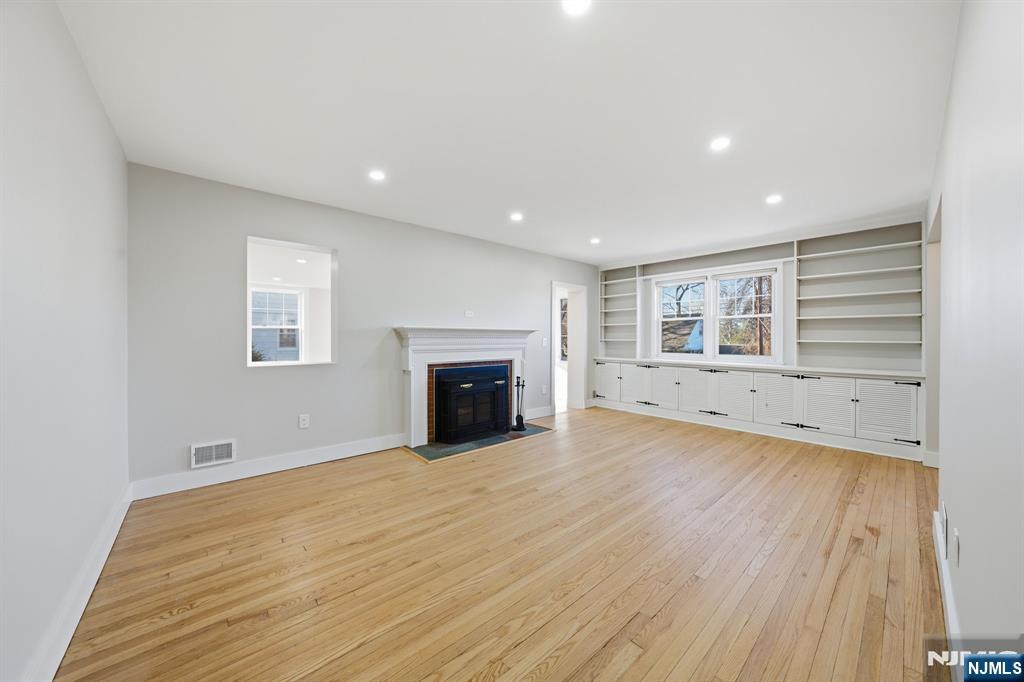 25 Forest Street Closter, NJ 07624 - Photo 14 of 48 a view of empty room with wooden floor and fireplace