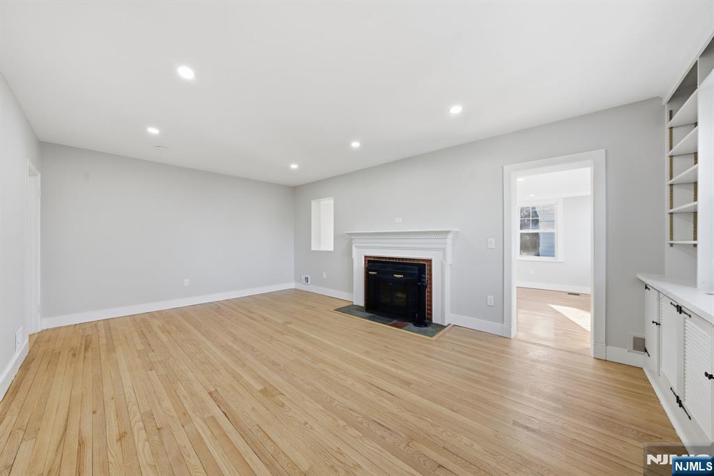 25 Forest Street Closter, NJ 07624 - Photo 21 of 48 a view of an empty room with wooden floor and a fireplace