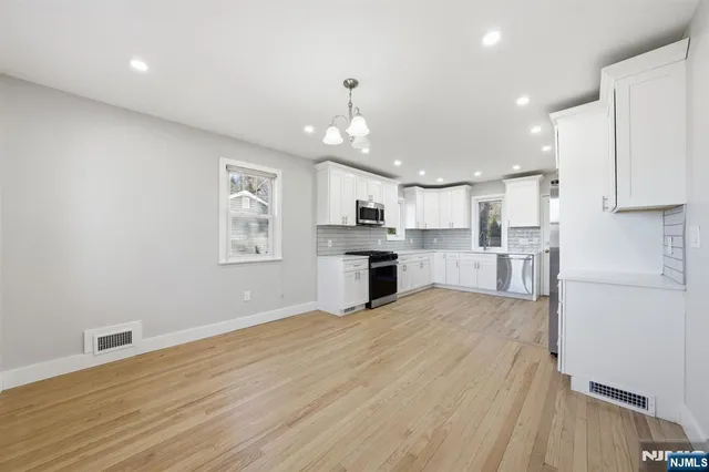 a view of kitchen with granite countertop cabinets and refrigerator