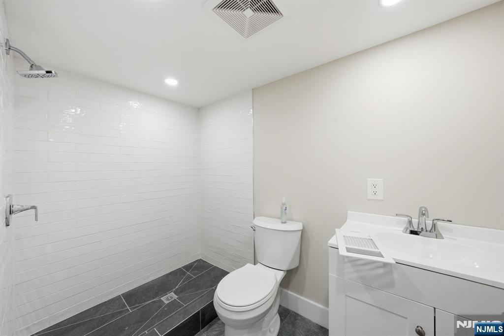 25 Forest Street Closter, NJ 07624 - Photo 33 of 48 a bathroom with a toilet a sink and mirror