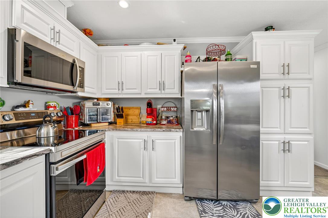 8792 Turkey Ridge Road Breinigsville, PA 18031 - Photo 11 of 33 a kitchen with stainless steel appliances a refrigerator sink and cabinets