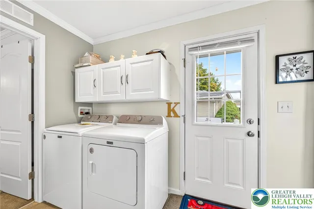 a utility room with a sink a cabinetry and a window