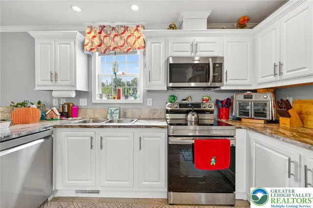 a kitchen with kitchen island granite countertop a sink stove and cabinets