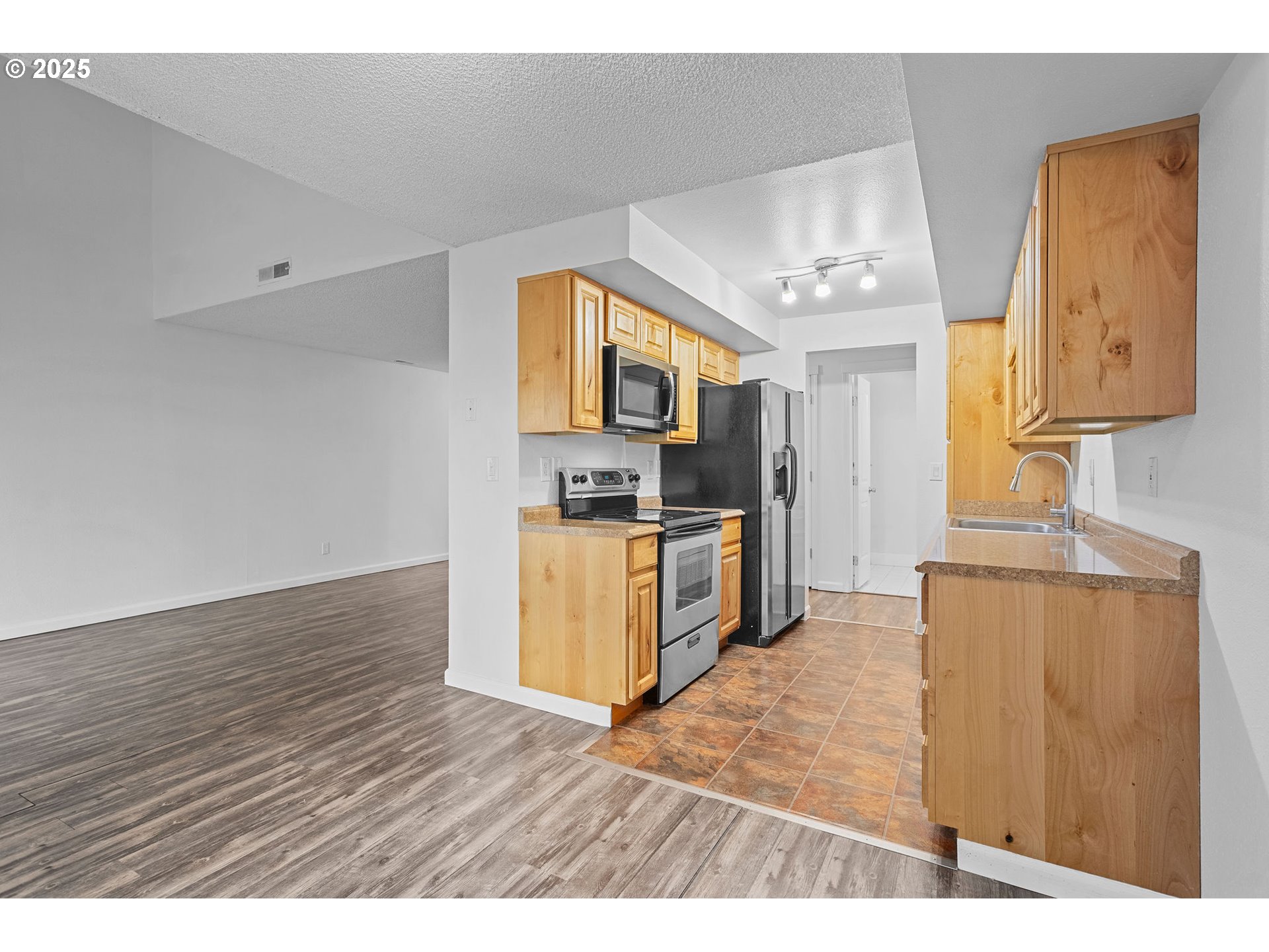 311 Northeast 85th Street, Unit R Vancouver, WA 98665 - Photo 12 of 34 a kitchen with granite countertop wooden floors and stainless steel appliances