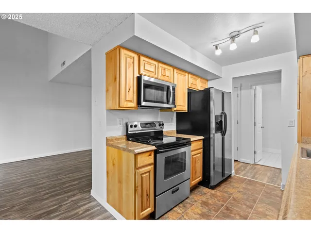 a kitchen with stainless steel appliances granite countertop a stove a refrigerator and a microwave