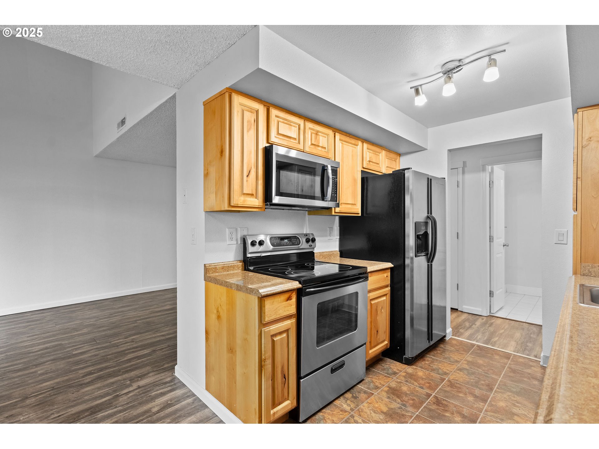 311 Northeast 85th Street, Unit R Vancouver, WA 98665 - Photo 14 of 34 a kitchen with stainless steel appliances granite countertop a stove a refrigerator and a microwave