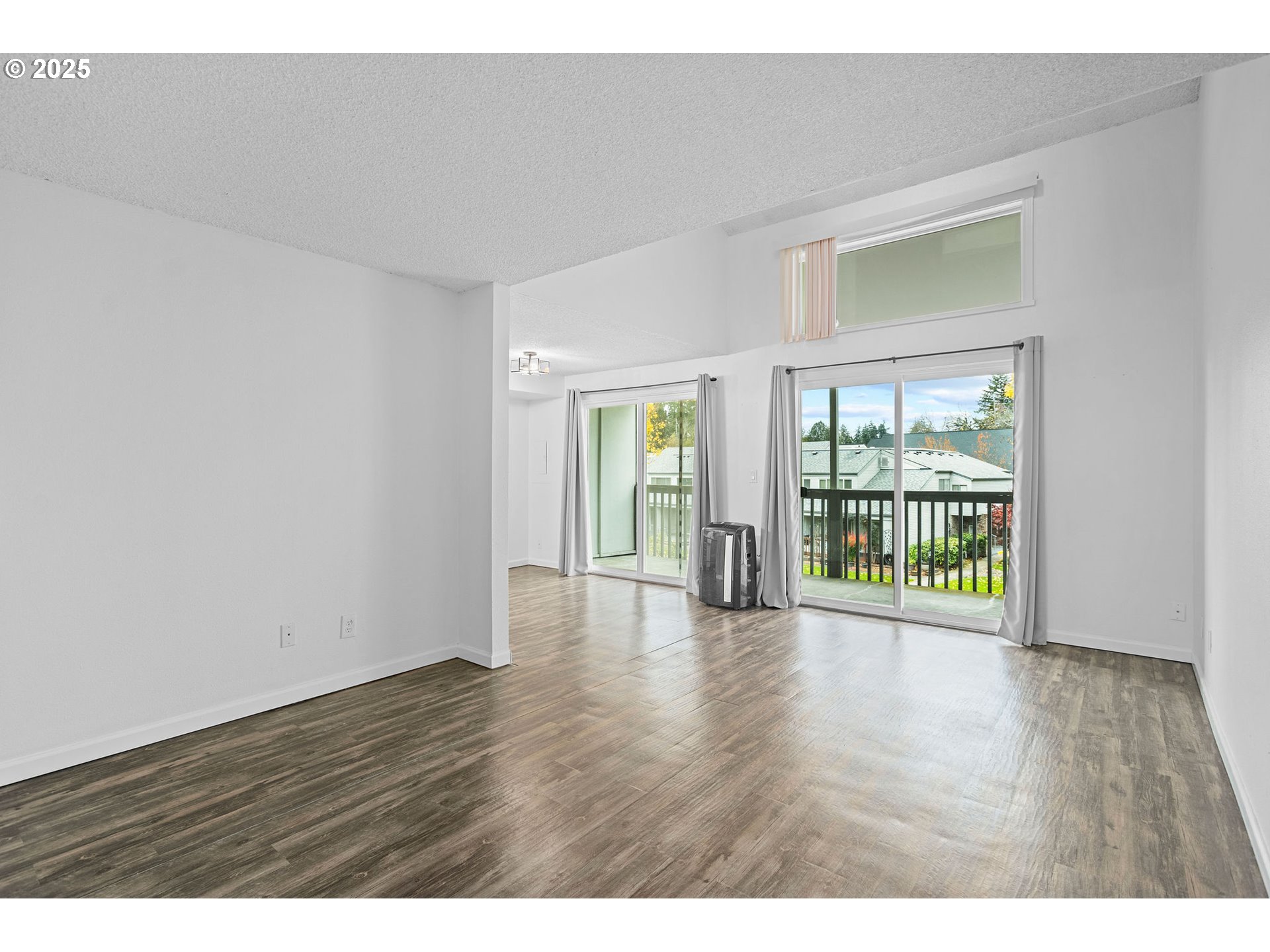 311 Northeast 85th Street, Unit R Vancouver, WA 98665 - Photo 6 of 34 a view of an empty room with wooden floor and a window