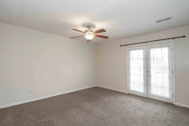 an empty room with a window and a fan