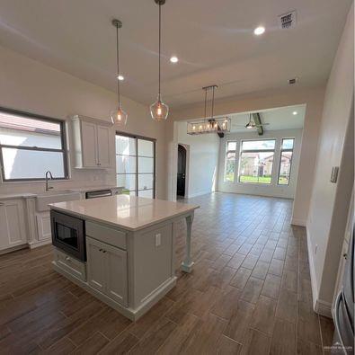 804 Grayson Avenue McAllen, TX 78504 - Photo 7 of 30 a kitchen with stainless steel appliances granite countertop a sink a stove and a wooden floors
