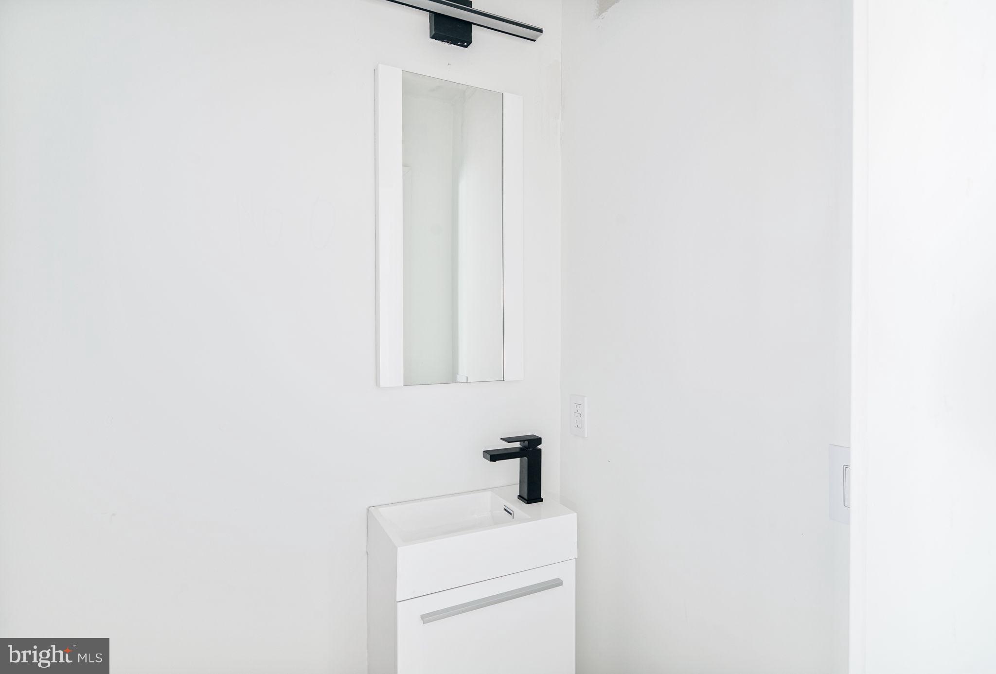 2607 East Boston Street, Unit 1 Philadelphia, PA 19125 - Photo 14 of 25 a bathroom with a sink a toilet and a mirror