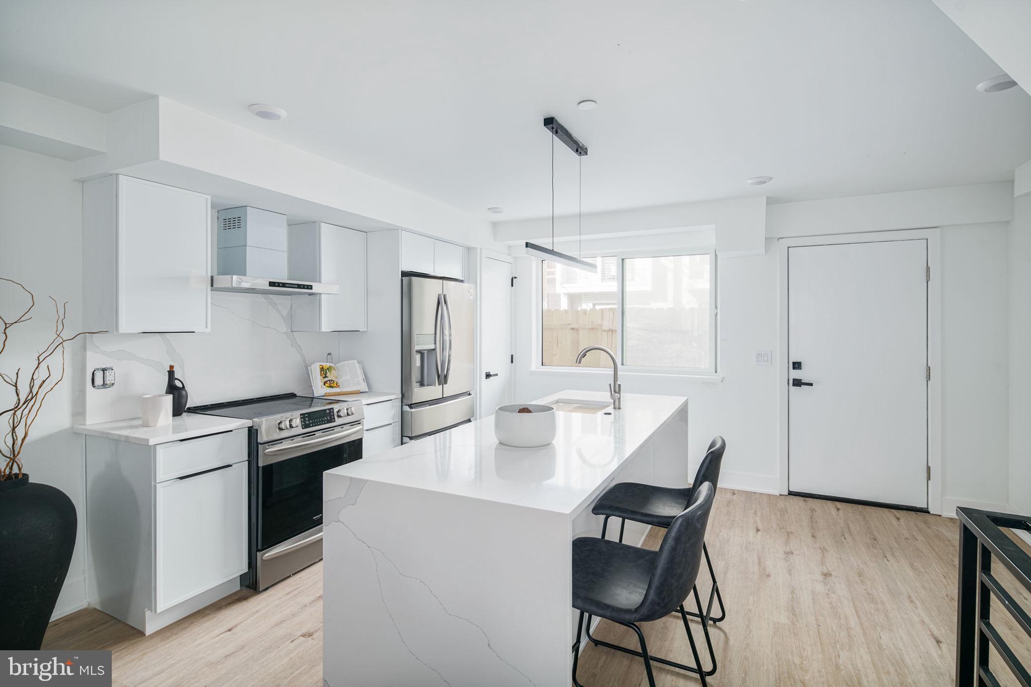 2607 East Boston Street, Unit 1 Philadelphia, PA 19125 - Photo 8 of 25 a kitchen with kitchen island a stove a table and chairs in it