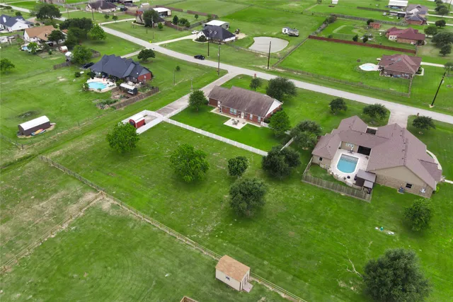 an aerial view of a residential houses with outdoor space and street view