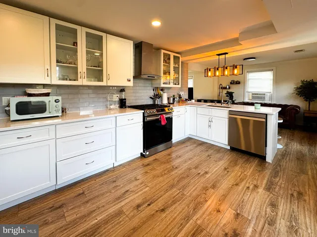 a kitchen with stainless steel appliances granite countertop a stove a sink dishwasher and a microwave oven with cabinets