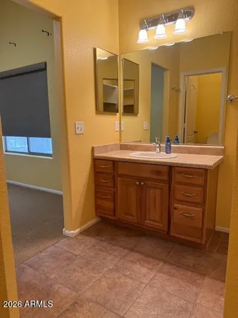 a bathroom with a sink and mirror with bathtub