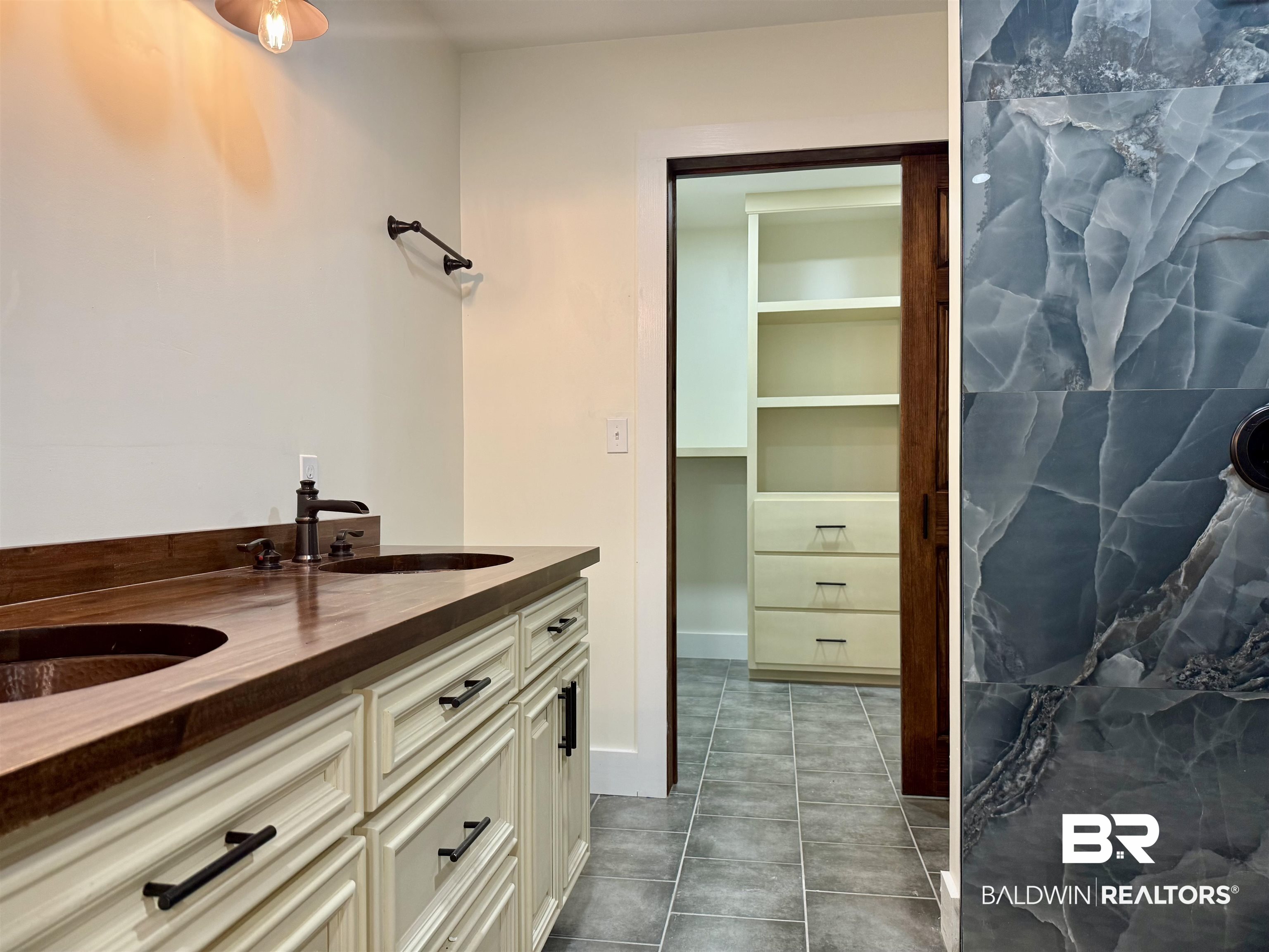 613 Forrest Avenue Brewton, AL 36426 - Photo 13 of 22 Full bath featuring double vanity, a walk in closet, and dark tile patterned floors