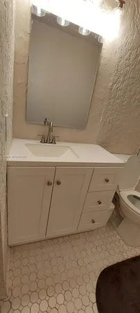 a bathroom with a sink a toilet and a mirror