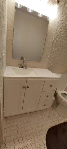 a bathroom with a sink a toilet and a mirror