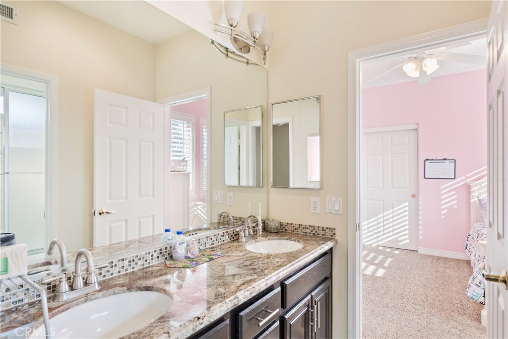 4954 Crestview Place Rancho Cucamonga, CA 91701 - Photo 38 of 40 a bathroom with a granite countertop sink a mirror and a shower