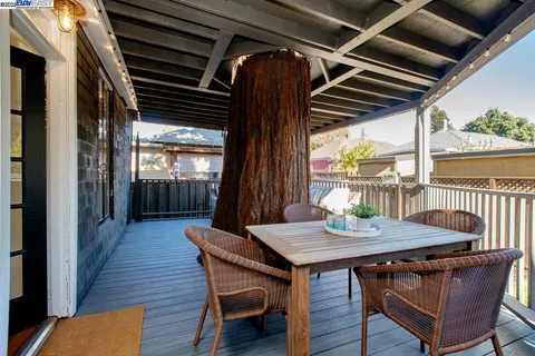 a view of a chair and table in backyard of the house