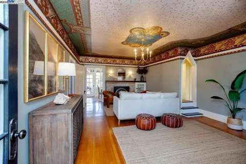 a living room with furniture a fireplace and a chandelier