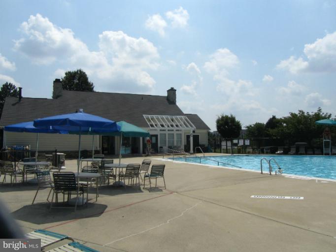 107 Bishopstone Circle Frederick, MD 21702 - Photo 20 of 21 a view of a patio with dining table and chairs under an umbrella