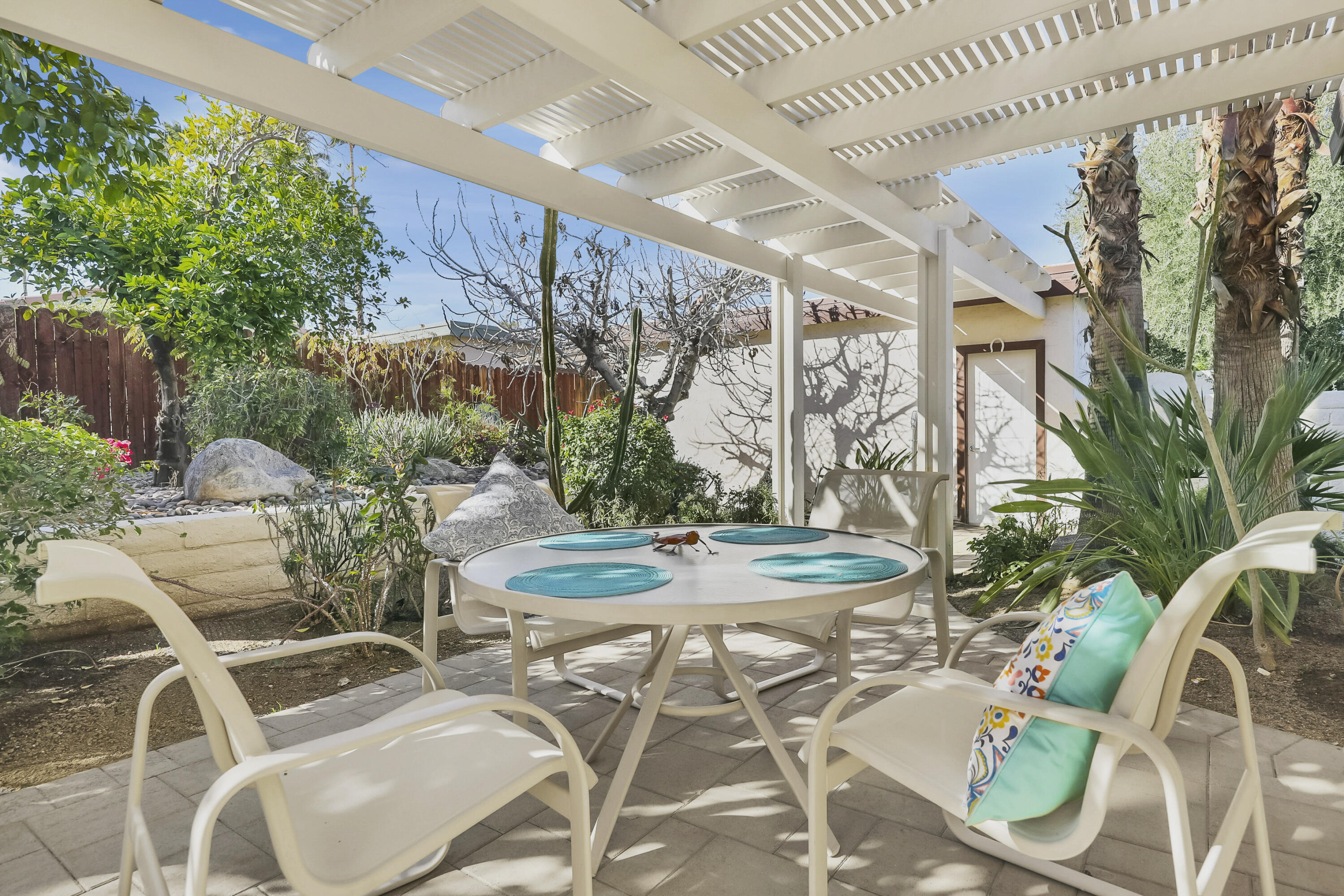 73517 Haystack Road Palm Desert, CA 92260 - Photo 18 of 26 a view of a patio with table and chairs potted plants and large tree