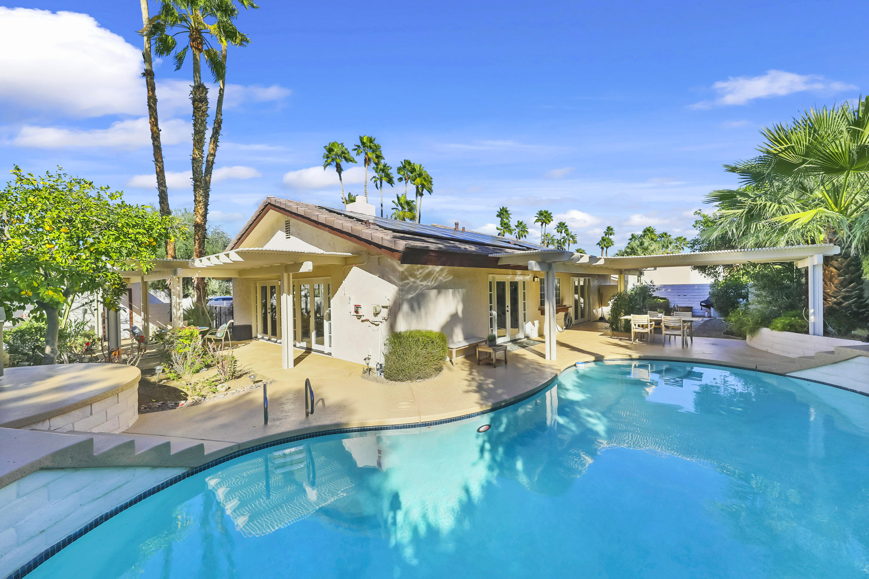 73517 Haystack Road Palm Desert, CA 92260 - Photo 2 of 26 a view of a house with swimming pool and sitting area