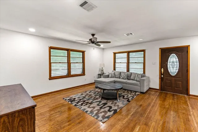 a living room with furniture and a wooden floor