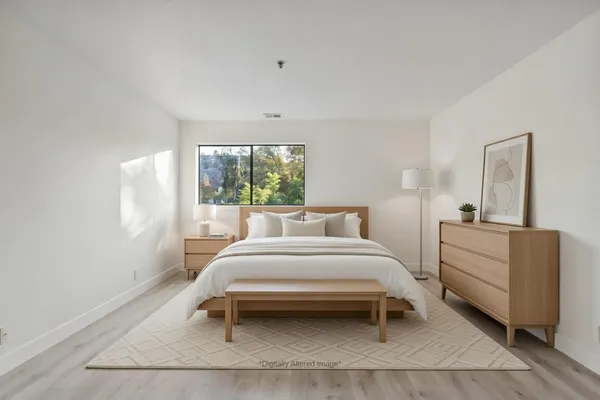 a bedroom with a bed and a large window