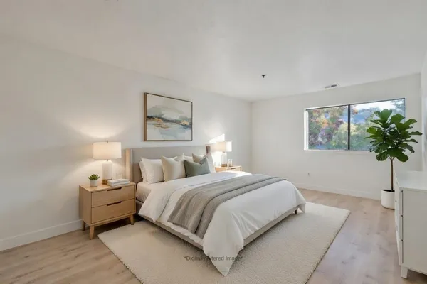 a bedroom with a bed and a potted plant