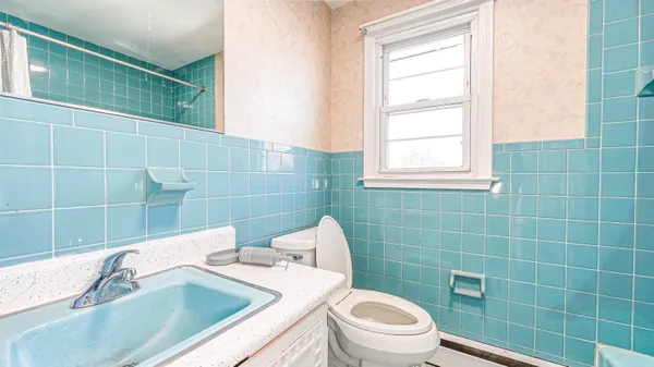 a bathroom with a sink a toilet and window