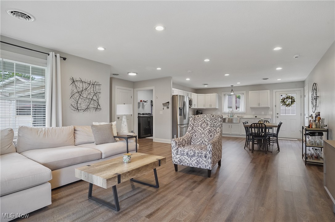 Living area featuring dark wood finished floors, recessed lighting, and baseboards