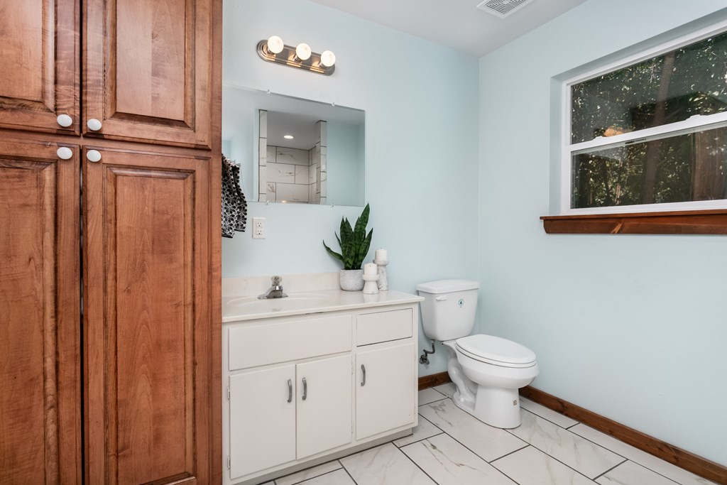 901 Bell Street Fredericksburg, TX 78624 - Photo 8 of 25 a bathroom with a toilet sink and mirror