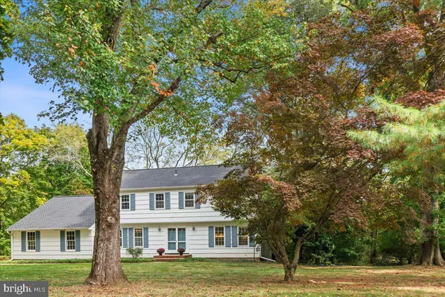 a front view of a house with a garden and trees