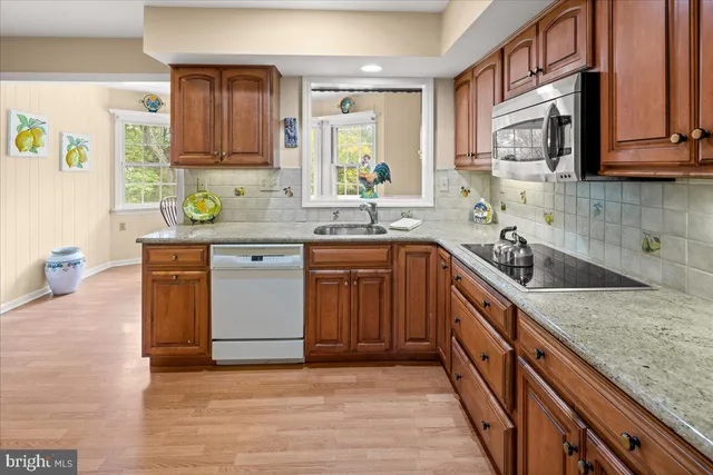 a kitchen with stainless steel appliances granite countertop a sink stove and cabinets