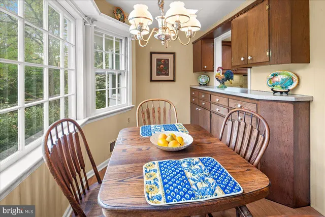 a view of a dining room with furniture a chandelier and wooden floor