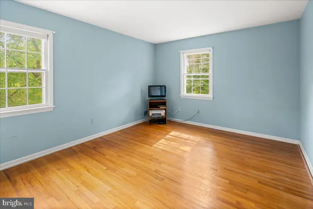 a front view of a house with a yard and a large tree