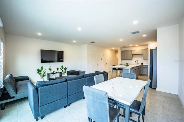 a living room with furniture a flat screen tv and a floor to ceiling window