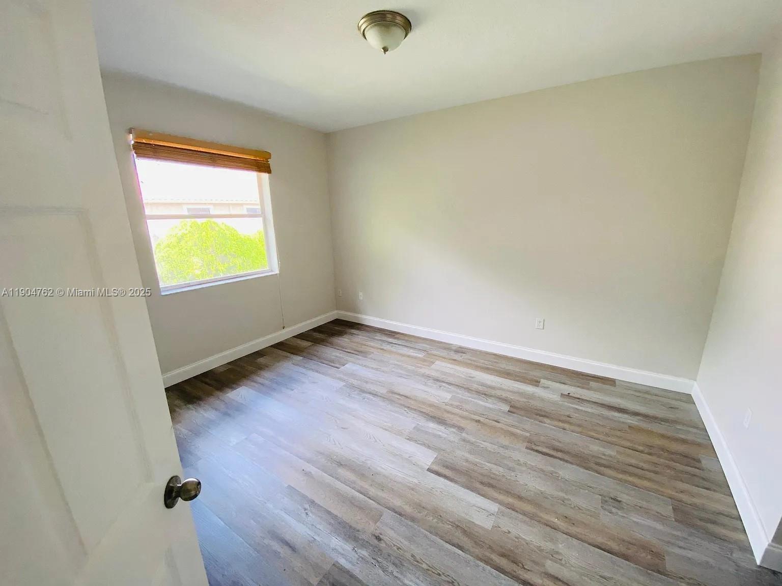4947 Southwest 135th Way Miramar, FL 33027 - Photo 6 of 17 wooden floor in an empty room